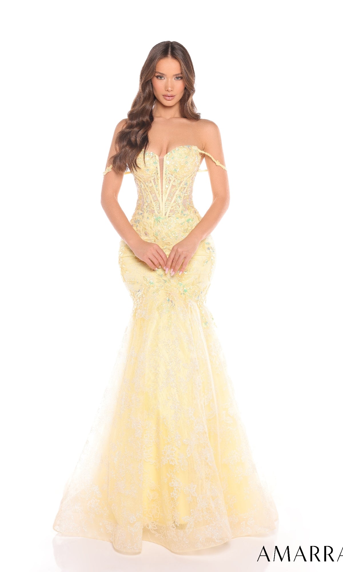 A woman poses against a white background in the Amarra 88373 long prom dress, featuring a fitted, off-the-shoulder yellow mermaid silhouette with a corset bodice and delicate floral lace detailing.
